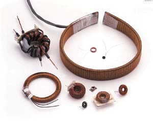 Assorted toroid coils in various sizes, including large ring-wound and small surface-mount designs, with copper wire windings.